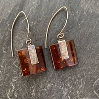 full view of both amber sterling earrings on slate background