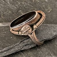 profile view of sterling ring showing elongated onyx stone and leaf detail
