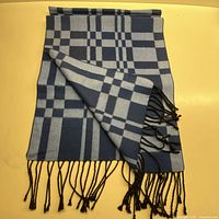 Full view of navy and light blue checked silk scarf with fringe