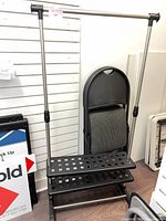 Front view of adjustable garment rack showing frame, shelves, and wheels