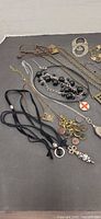 Assorted necklaces, pendants and cord pieces spread on surface