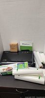 Vacuum sealer with manual, attachment box, bag rolls and supplies