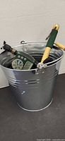 Galvanized pail containing timer and hand tool