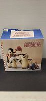 Retail box front showing wood-look penguins set
