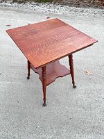 Full view of tiger oak parlor table showing top, legs, shelf and claw feet