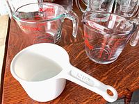 Three measuring cups: Pyrex glass, Anchor Hocking glass, white plastic