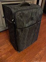 Suitcase front showing pattern, front zip pocket and wheels