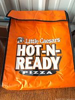 Front view showing logo, orange exterior, Velcro flap