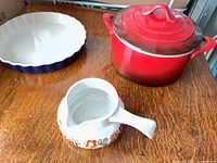 Group shot showing red pot with lid, blue pie plate, floral gravy boat