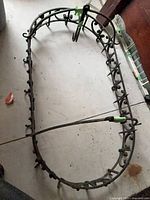 Full view of oval wrought iron pot rack lying on floor