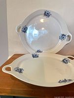Two blue and white handled serving plates, top and angled view