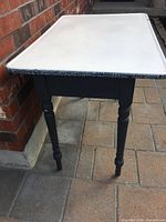 Full view of enamel-top table against brick wall