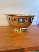 Side view of polished brass footed bowl