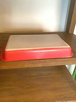 Rectangular Pyrex casserole upside down showing flamingo pink exterior