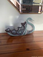 Side view of full glass swan bowl on wooden surface