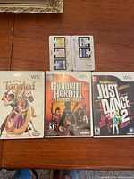Front view of three Wii games and open DS card case showing five cartridges