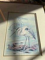 Close-up of heron print showing artist signature, matting, partial frame