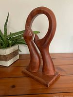 Front view of wooden hand sculpture on base