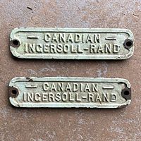 Front of both plaques showing raised lettering and paint wear