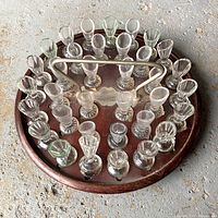 Top view of wooden communion caddie filled with 35 glass cups and metal handle