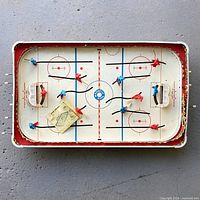 Full view of tabletop hockey game showing rink, players, nets and instruction sheet