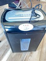 Front view of Insignia NS-PS10MC shredder with cord