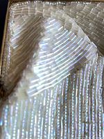 Close view of ivory bugle-bead surface and gold-tone frame