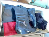 Boot pairs stacked in bin showing various colours and styles