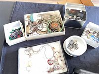 Overview of entire lot in multiple boxes showing assorted jewelry pieces
