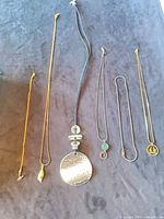 All six necklaces laid out showing full length and pendants