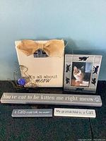 Front view showing five of the six cat quote prints and signs