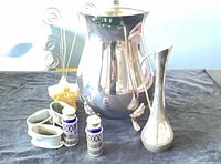 Group view of all silver plated items: pitcher, bud vase, shell dish with photo holders, pair cobalt shakers, pair footed bowls