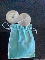 Clock and pouch together, lid partly open
