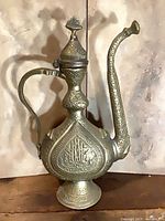 Full view of brass ewer showing overall form, lid, handle and spout