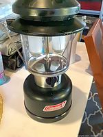 Front view of Coleman battery lantern showing logo, globe and handle