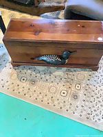 Full view of wooden chest with loon on front