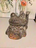 Front view of cast metal frog figure