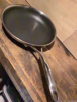 Top view of stainless frying pan showing dimpled cooking surface and overall condition