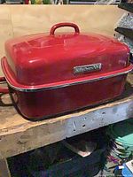 KitchenAid red enamel roasting pan with lid on workbench