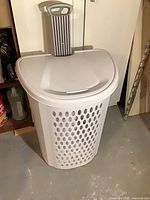 Front view of white plastic wheeled hamper with perforated sides and lid