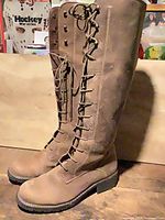 Full view of both tall lace-up leather boots