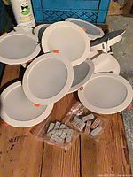 Stack of LED pot lights showing front diffusers and white trim