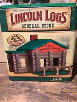 Front of Lincoln Logs General Store canister showing brand, set name and cabin image