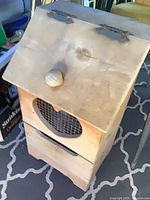 Front view of wooden potato bin showing hinged lid with knob and heart cutout with mesh