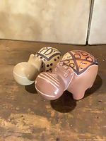 Two painted soapstone hippo figurines standing on wooden surface
