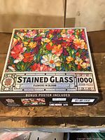 Front of sealed puzzle box showing floral stained glass image and piece count