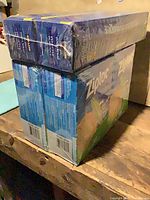 Two shrink-wrapped boxes food wrap atop two shrink-wrapped boxes Ziploc bags