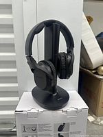 Headphone set on transmitter stand placed atop box front