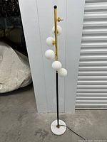 Full view of floor lamp showing globes, pole, base