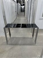 Front view of console table showing glass top and chrome legs
